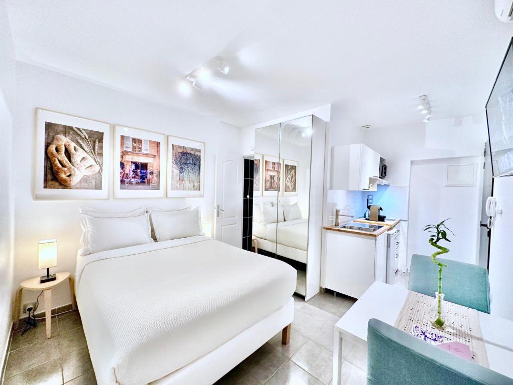 - une chambre blanche avec un lit blanc et une cuisine dans l'établissement Èrsextius, SF, Aix-en-Provence, à Aix-en-Provence