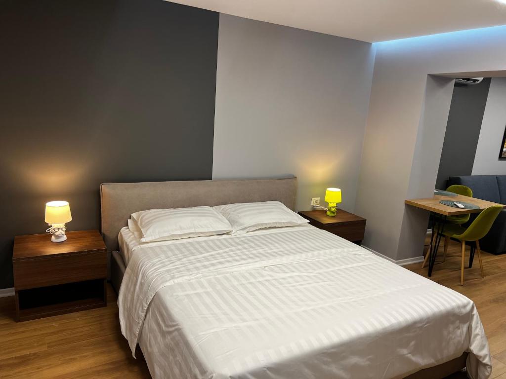 um quarto com uma cama e duas mesas com candeeiros em Dan apartment Tirana em Tirana