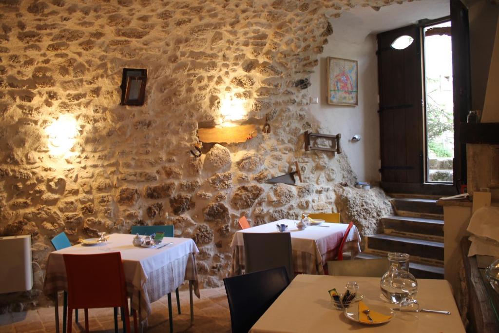 un ristorante con due tavoli e un muro di pietra di Le Pagliare Del Gran Sasso ad Assergi