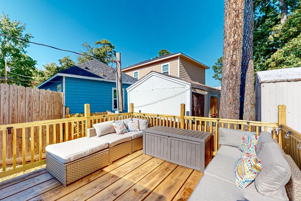 a patio with a couch and a table on a wooden deck at The Geography House in Montgomery