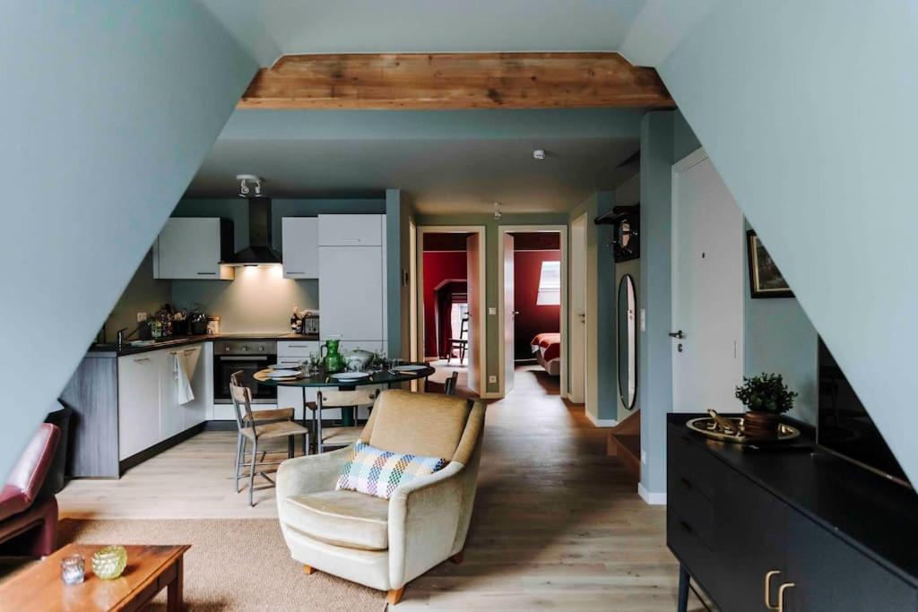eine Küche und ein Wohnzimmer mit einem Sofa und einem Tisch in der Unterkunft L’écrin vintage - Hors Château & Marches de Bueren in Lüttich