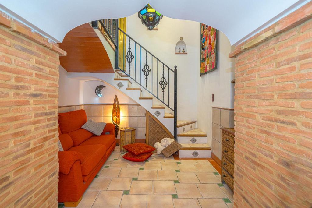 sala de estar con sofá naranja y escaleras en Verda, en Sella