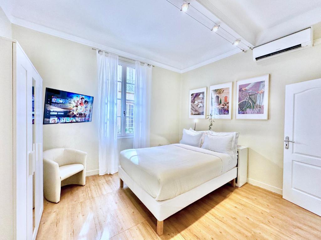 une chambre blanche avec un lit et une chaise dans l'établissement Èrsextius, MG, Aix-en-Provence, à Aix-en-Provence