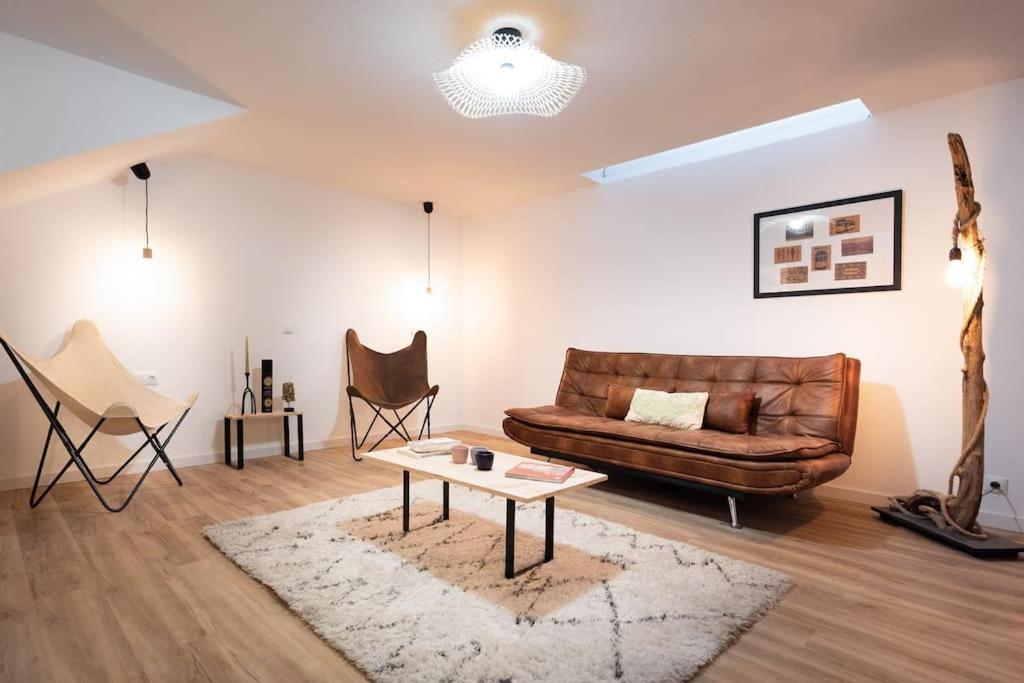 uma sala de estar com um sofá de couro e uma mesa em L'Atelier - Warm Porto Loft em Porto