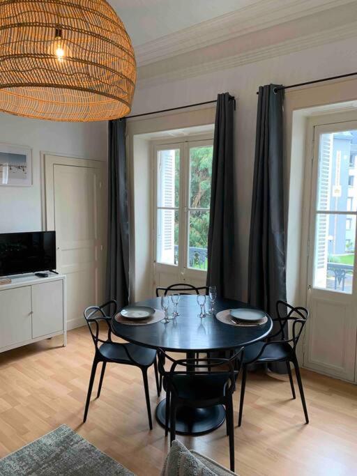 une salle à manger avec une table et des chaises noires dans l'établissement Beau studio au cœur de Dinard, à Dinard