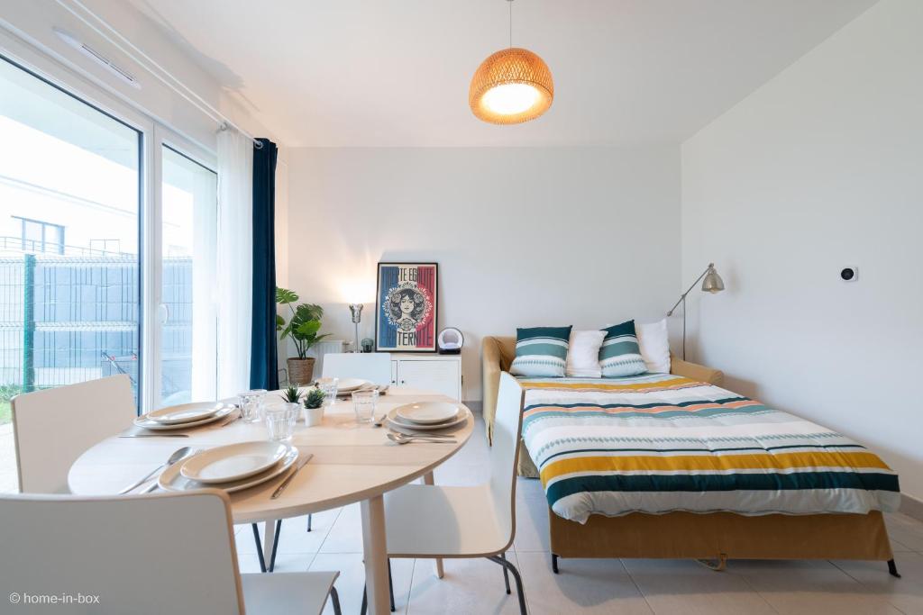een slaapkamer met een bed en een tafel en stoelen bij Bouton d'Or for 4 - Fairytale Factory in Ferrières-en-Brie