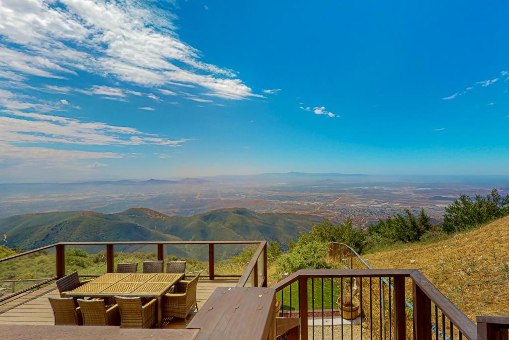 eine Holzterrasse mit einem Tisch und Stühlen auf einem Berg in der Unterkunft Skyline Ridge in Crestline