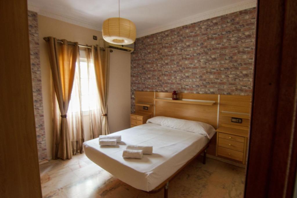 a bedroom with a bed and a brick wall at RentalSevilla Centrico Apartamento junto al Guadalquivir con Parking coche mediano in Seville