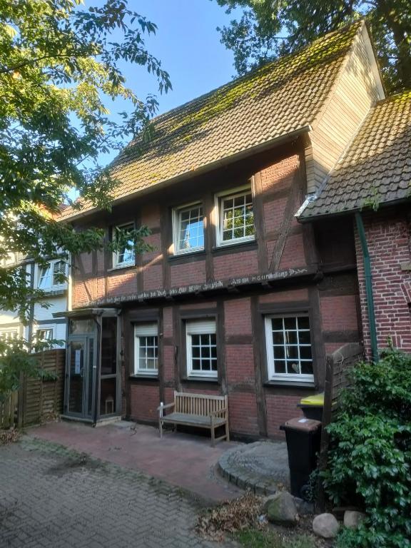 a brick house with a bench in front of it at Fachwerkhaus in Alfhausen in Alfhausen