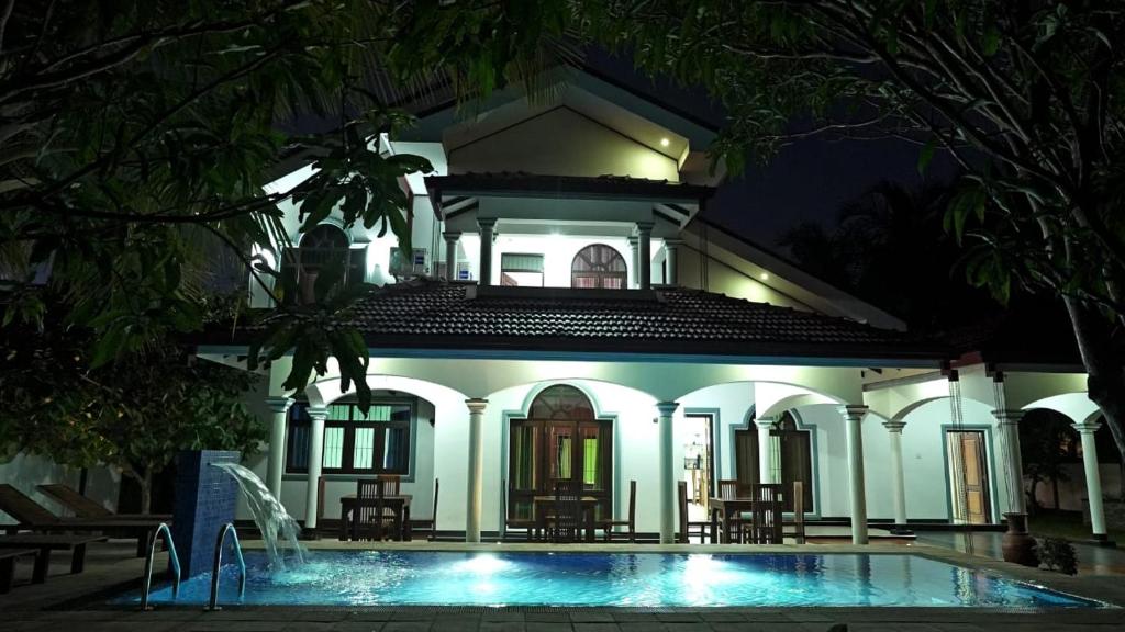Villa con piscina por la noche en Sri Ra'anana Villa, en Marawila