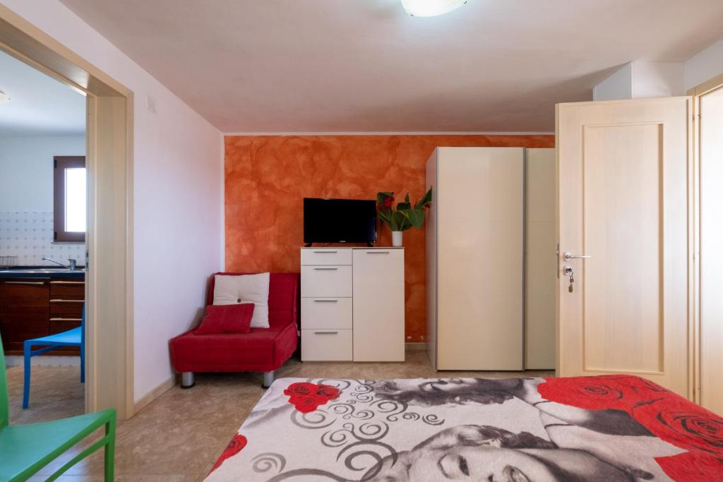 1 dormitorio con 1 cama y 1 silla roja en Terrazza Salentina, en Tricase