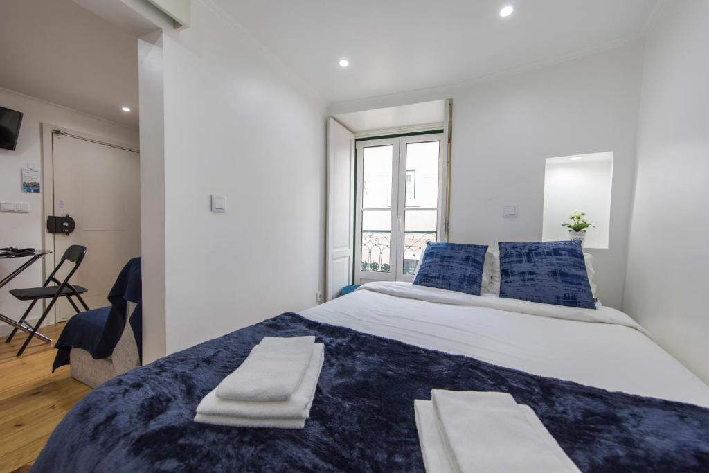 um quarto com uma cama grande e almofadas azuis em 133 B - My lovely house in Alfama with AC em Lisboa