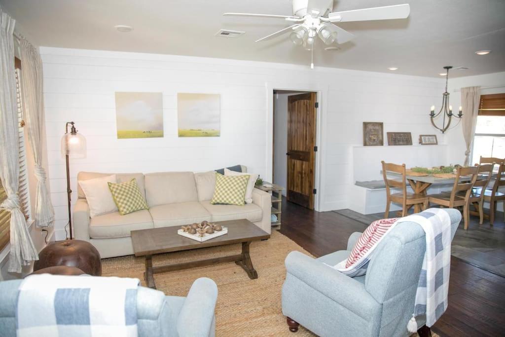 ein Wohnzimmer mit einem Sofa, Stühlen und einem Tisch in der Unterkunft Farm Cottage on homestead 20 min to Waco in Waco