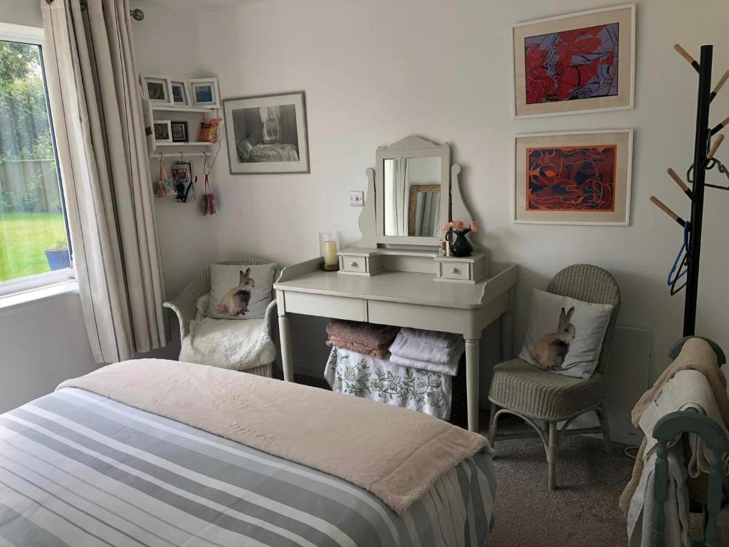 The Guest Suite, Buttsfield Lane. في East Hoathly: غرفة نوم بسرير ومغسلة ومرآة