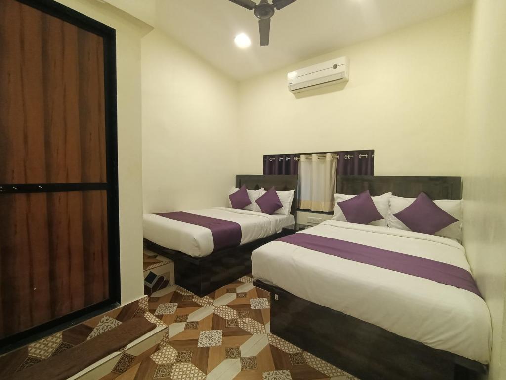a bedroom with two beds with purple pillows at Hotel Star of Kurla - Nearest from Kurla - Near BKC in Mumbai