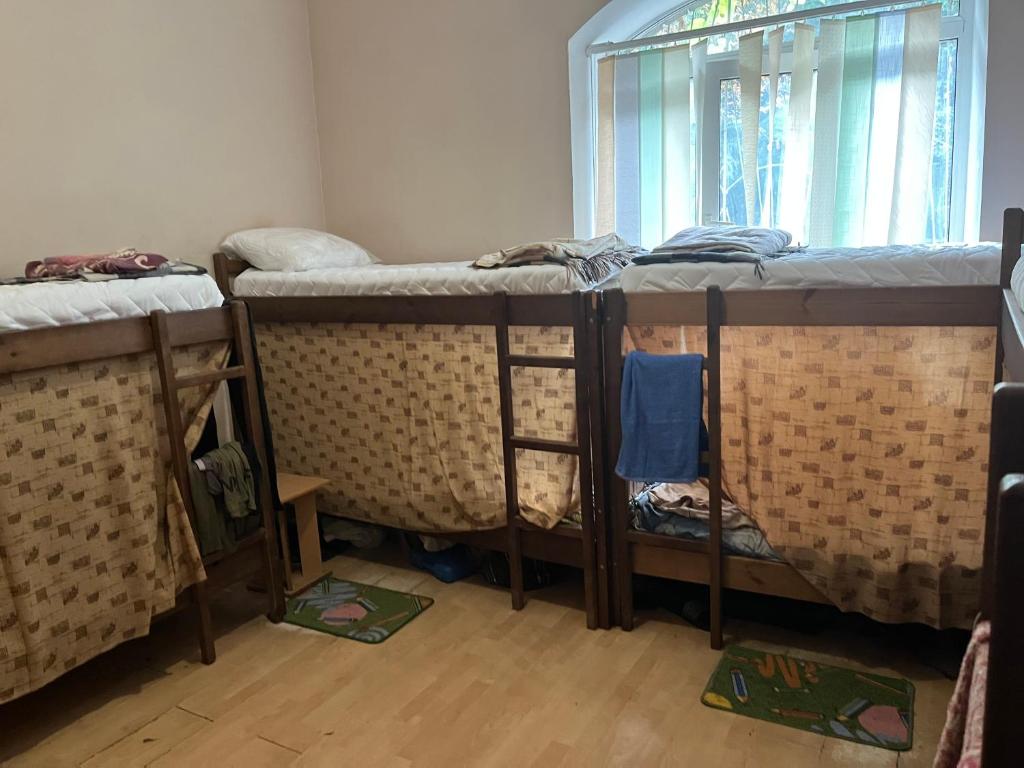 three bunk beds in a room with a window at ArArAt-HOLOSIIVSKYI Hostel KYIV in Kyiv