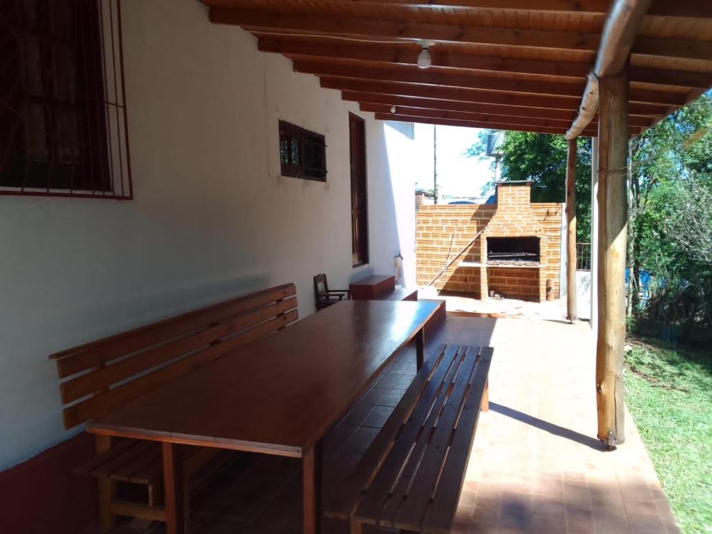 a wooden bench sitting in a room with a table at Casa del Río in Puerto Iguazú