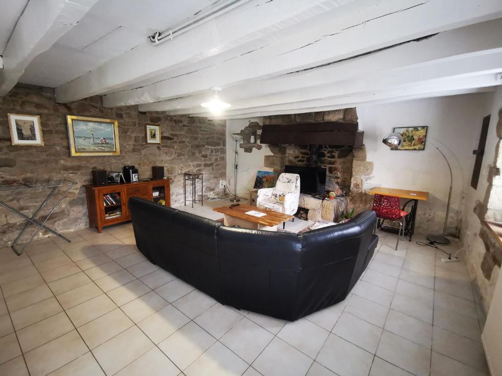 ein Wohnzimmer mit einem Sofa und einem Steinkamin in der Unterkunft jolie longère dans un hameau de Bubry in Bubry