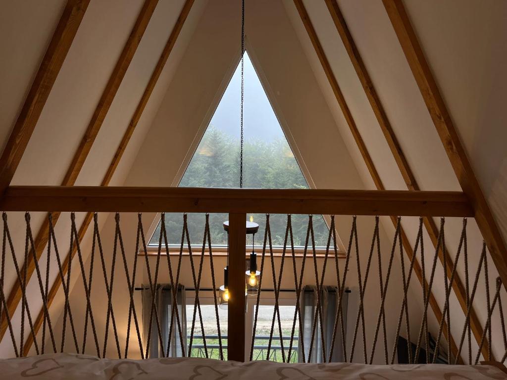 a large window in a room with a bed at Alpi Cabin Pridolci in Busovača