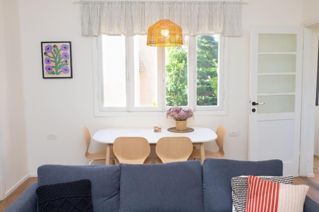 a living room with a blue couch and a table at Bright and Cozy Bauhaus Gem in Ra‘ananna