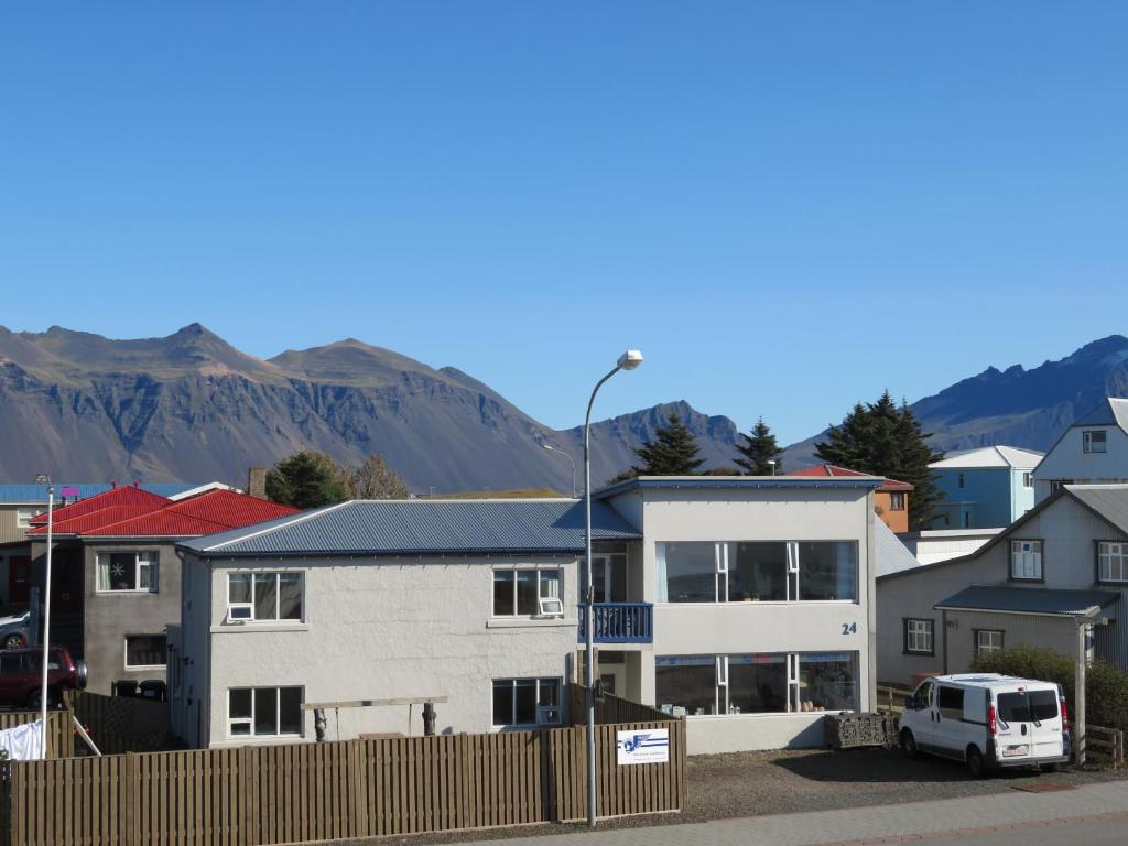 una furgoneta blanca estacionada frente a un edificio en Old Airline Guesthouse en Höfn