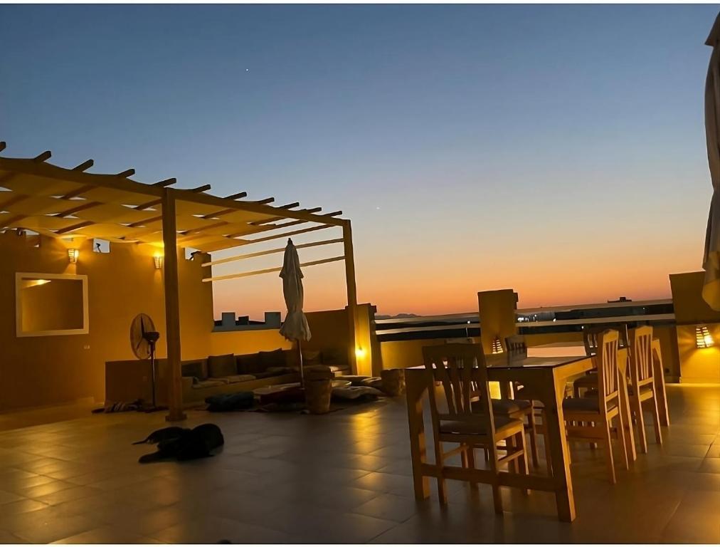 a cat laying on the floor next to a table and chairs at Alam B&B in Marsa Alam City