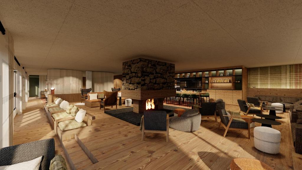 a lobby with a fireplace and chairs and tables at Belambra Clubs Les 2 Alpes Les Crêtes in Les Deux Alpes