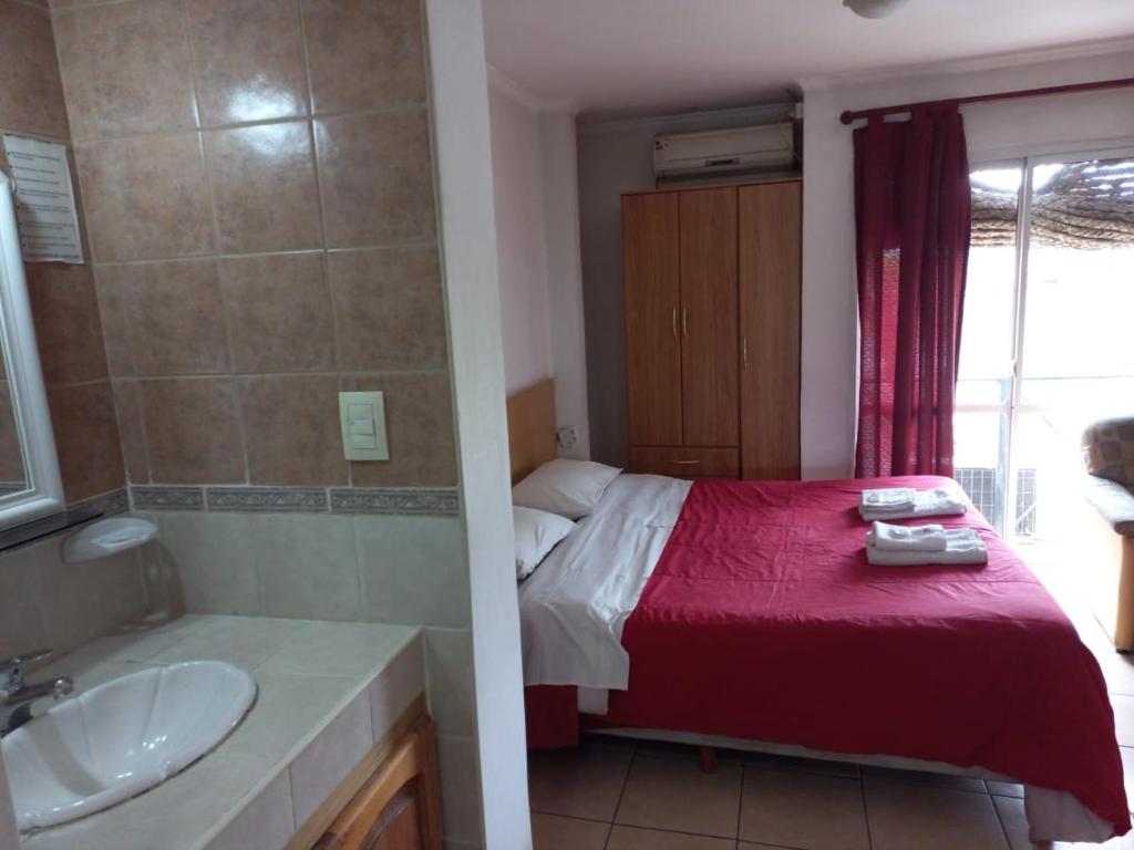 y baño con cama, bañera y lavamanos. en Apart Hotel Malbec en Luján de Cuyo