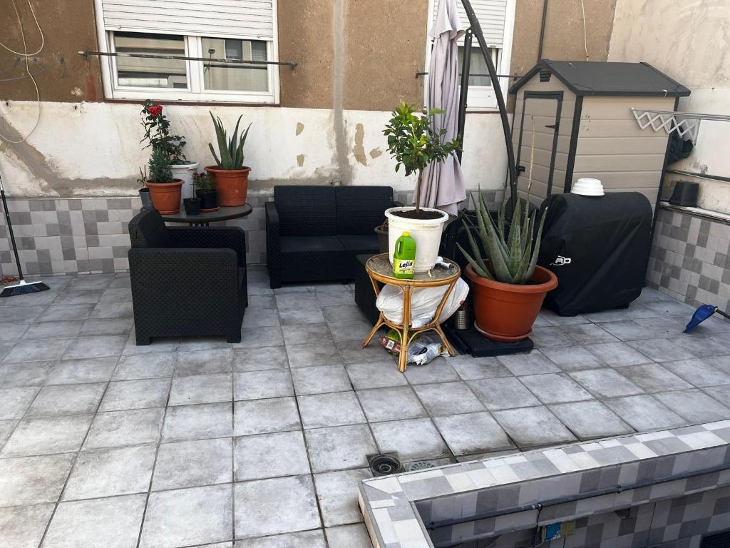 a patio with chairs and potted plants on it at Habitación privada en Hospitalet de llobregat in Hospitalet de Llobregat