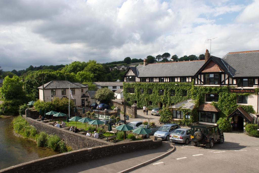 a village with cars parked in front of a building at Exmoor White Horse Inn in Exford