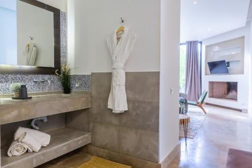 y baño con lavabo y espejo. en Villa Marrakech Palmeraie Lux, en Marrakech