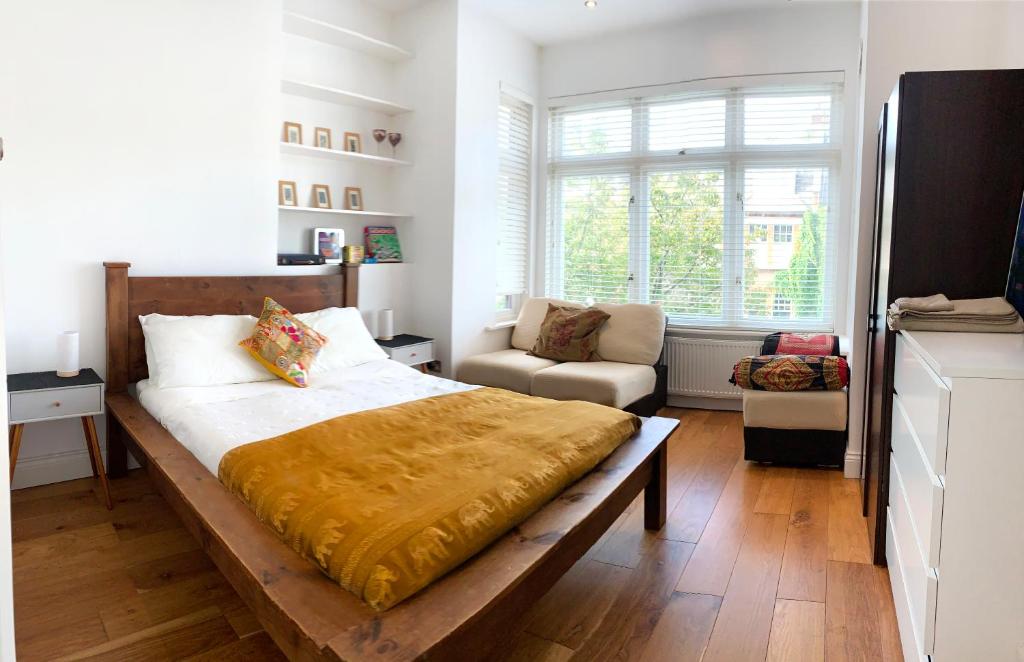 1 dormitorio con 1 cama grande y 1 silla en Central Location 2 bed flat, Zone II, London NW6 en Londres