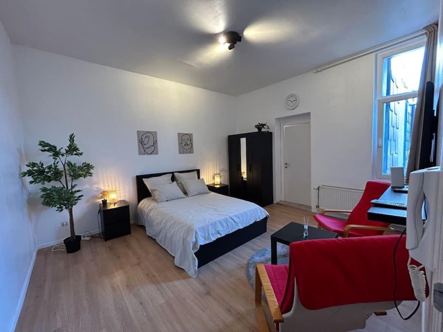 ein weißes Schlafzimmer mit einem Bett und ein Wohnzimmer in der Unterkunft Laeken : Cocon Chaleureux & Confort in Brüssel
