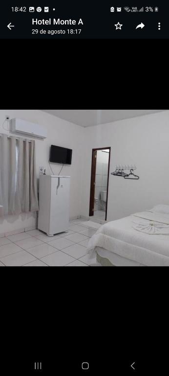 a picture of a bedroom with a bed and a television at Hotel Monte Arau in Boa Vista