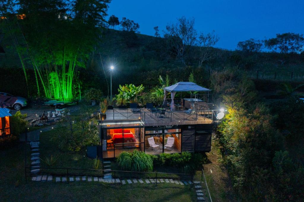 una vista aérea de una casa en un jardín por la noche en Glamping Montecarlo Lodge Cubo de Madera-Guatapé, 