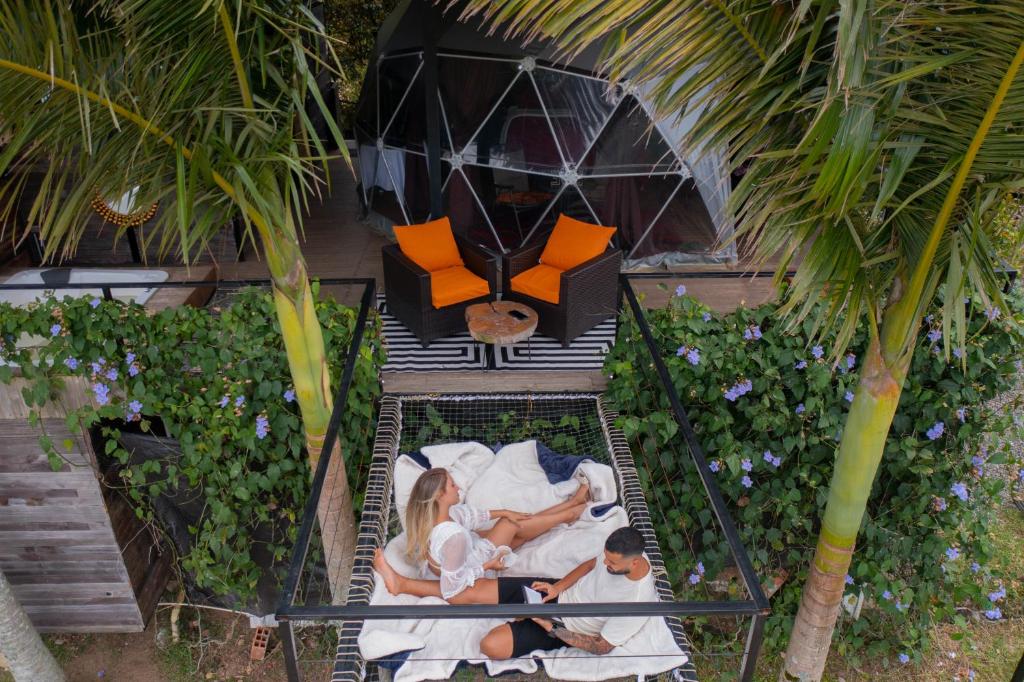 an aerial view of a family laying in bed at Glamping Montecarlo Domo Geodesico y Sauna Finlandés Guatapé in Guatapé