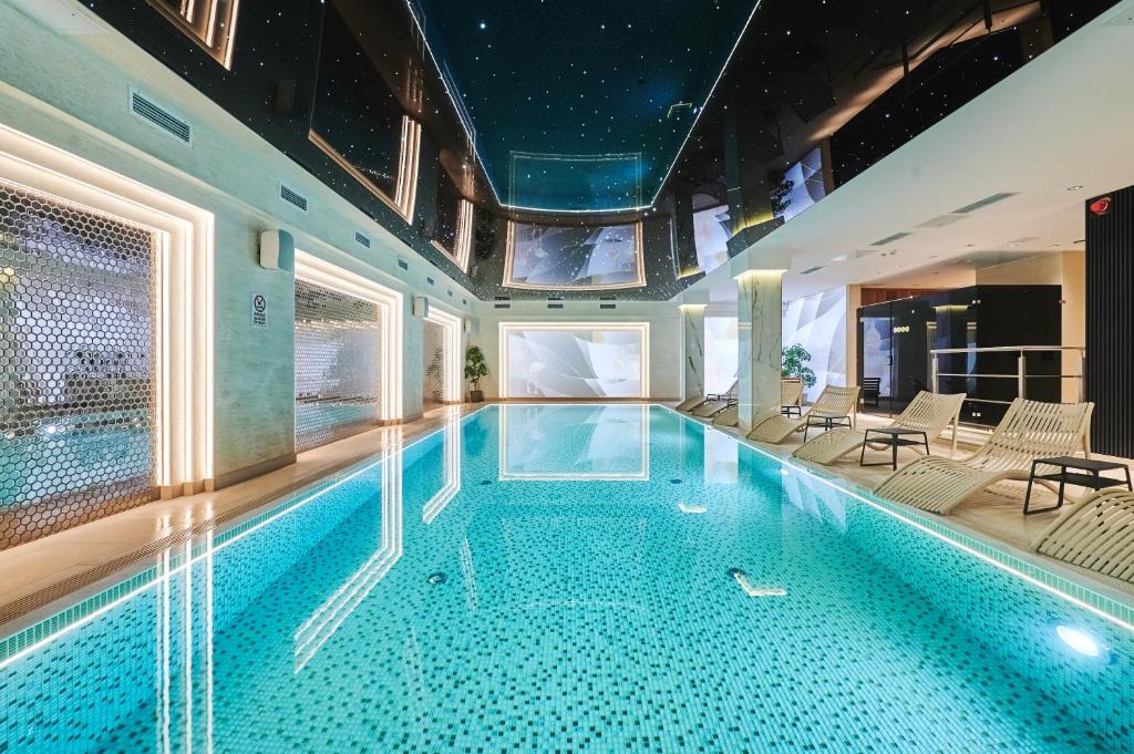 a swimming pool in a hotel with chairs and tables at Stay inn Hotel Warszawa in Warsaw