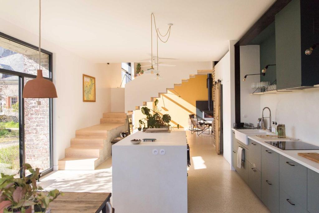 an open kitchen with stairs in the background at Maison d'hôtes le détour en pleine nature in Channay-sur-Lathan