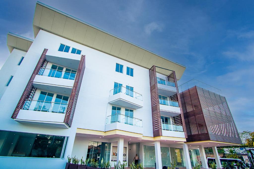 a white building with balconies on the side of it at HOTEL EL NARANJO in Acacías