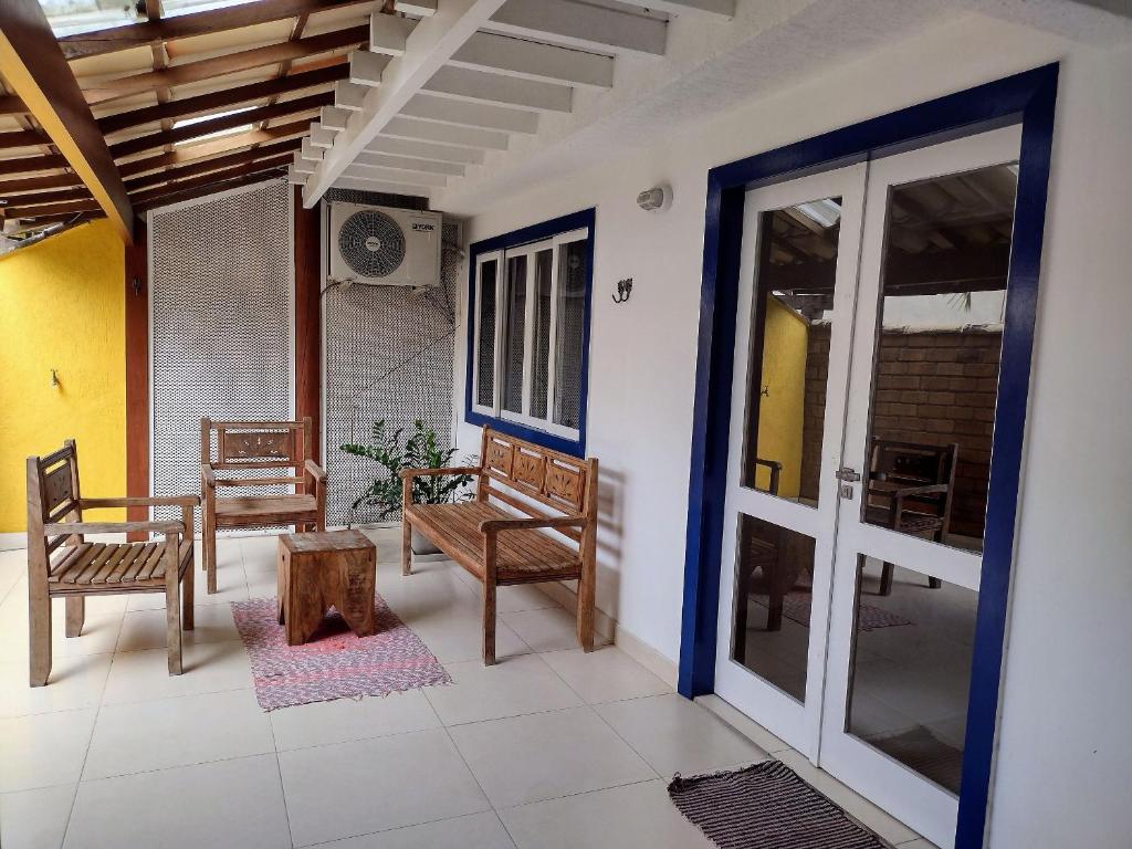 a porch with chairs and a door and a table at Casa com garagem - 300m da Rua das Pedras in Búzios