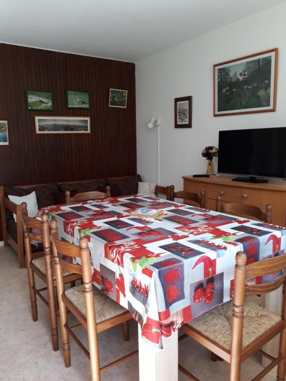 - une salle à manger avec une table et une couette dans l'établissement Mongie Appart, à Bagnères-de-Bigorre