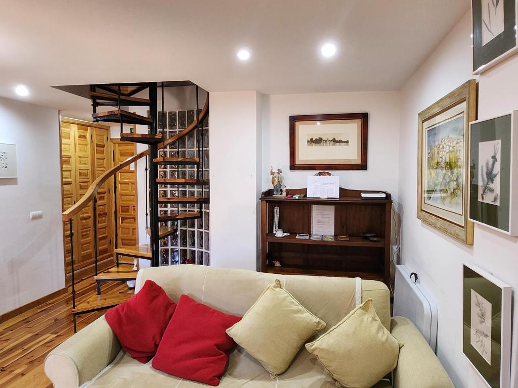 sala de estar con sofá y escalera de caracol en La casa sobre el rÍo, en Cuenca