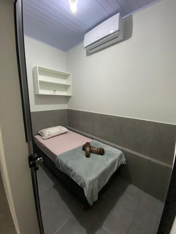 Habitación pequeña con cama pequeña y ventana en Hostel Araxá, en Araxá
