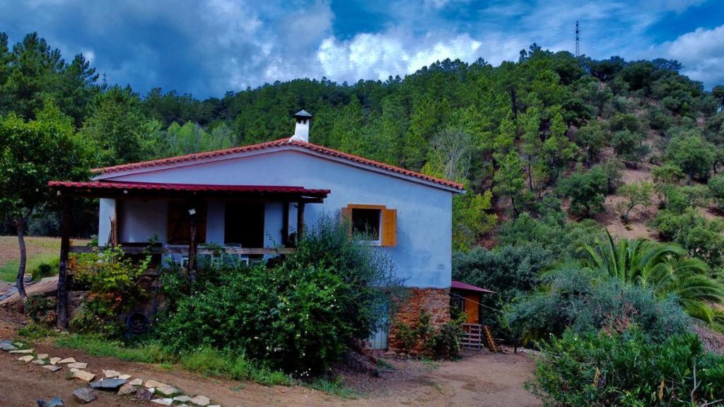 una pequeña casa blanca en medio de un bosque en Finca Casa Charco La Olla, en La Nava