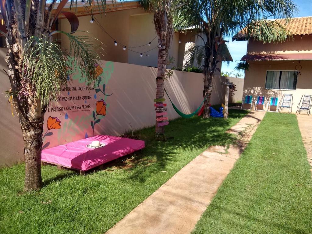 un colchón rosa tirado en el césped junto a una casa en Casa Viva Bonito en Bonito