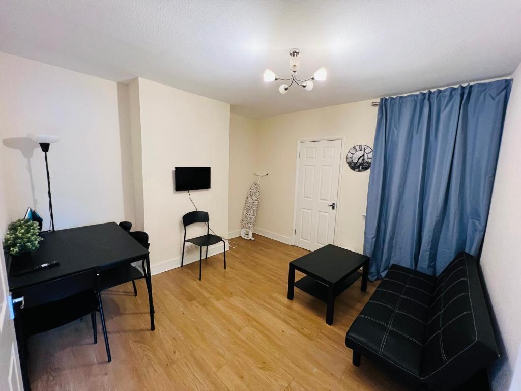 a living room with a piano and blue curtains at Three Bedroom House with private car park in London