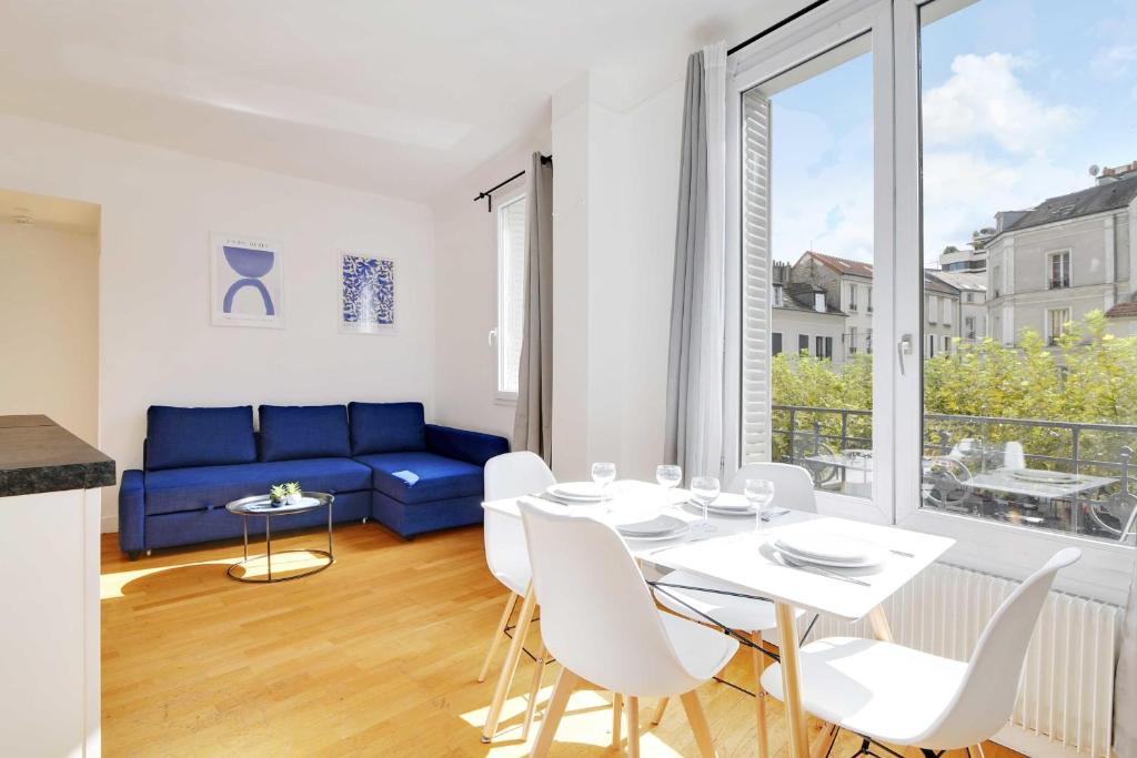 sala de estar con sofá azul, mesa y sillas en Superb 2BR apartment - Suresnes en Suresnes