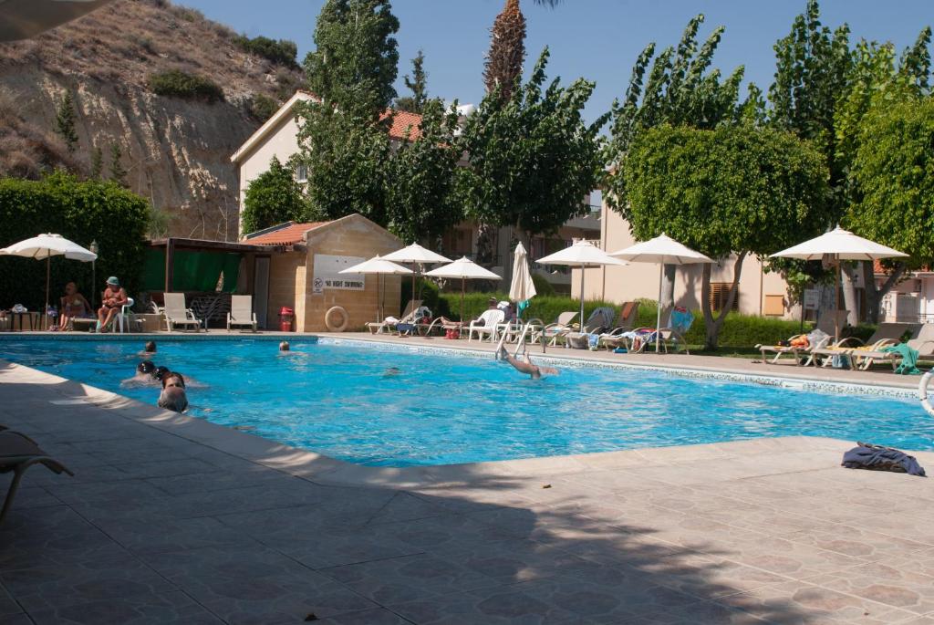 una gran piscina con gente. en Kotzias Beach Apartments, en Pissouri