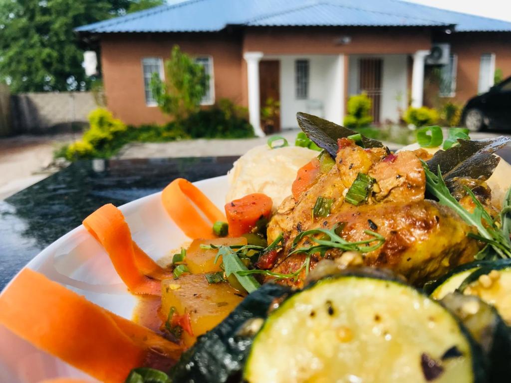 un plato de comida con verduras en una mesa en Jayla Homestay, en Maun