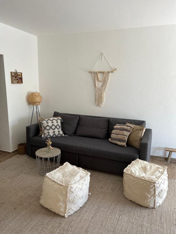 sala de estar con sofá y 2 reposapiés en Ländliche Fewo Wildblume, 4 km zum Stausee en Happurg